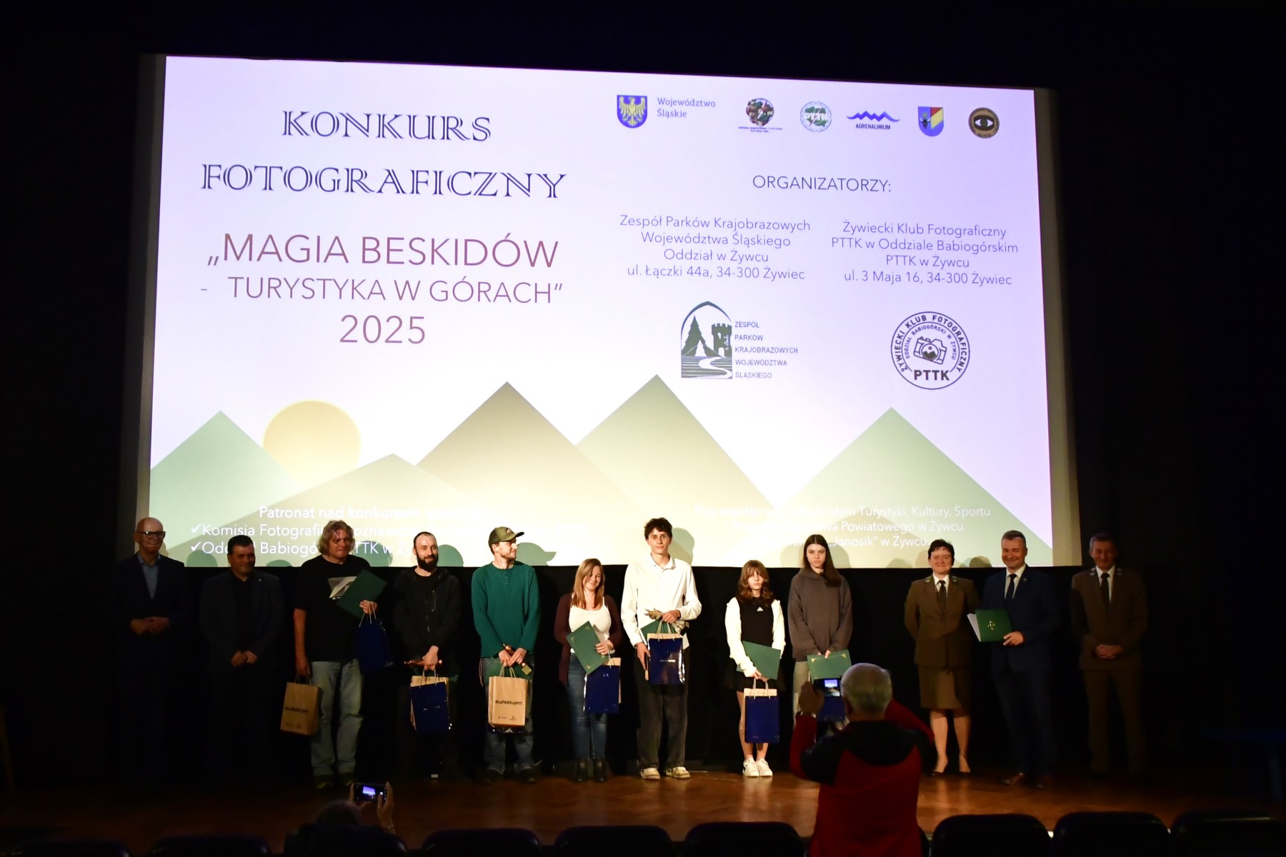 Zdjęcie grupowe organizatorów oraz laureatów konkursu na sali kinowej. 