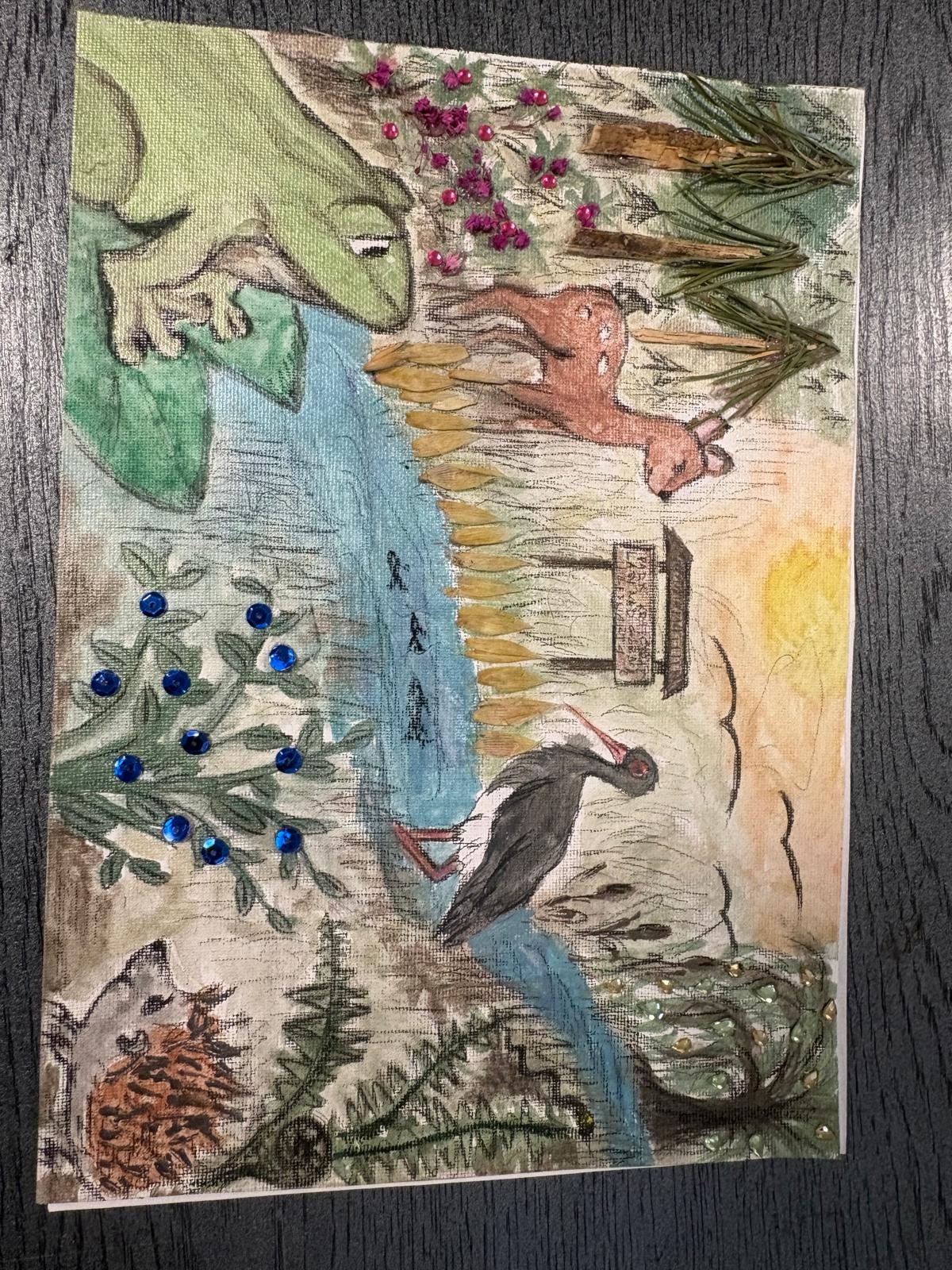Zdjęcie przedstawia wielowarstwowy rysunek z elementami kolażu przedstawiający las nad strumieniem. Na ilustracji widać bociana czarnego, jelenia, dużą zieloną żabę oraz jeża. Praca została ozdobiona przestrzennymi elementami: błyszczącymi niebieskimi i różowymi cekinami oraz prawdziwymi igłami sosnowymi.
